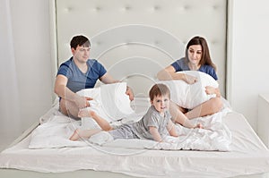 Little boy and parents On Parents Bed Wearing Pajamas