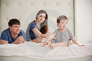 Little boy and parents On Parents Bed Wearing Pajamas
