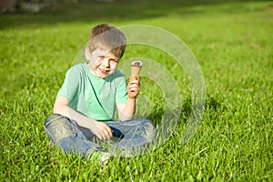 Little boy in park eating ice cream