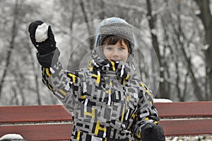The little boy in the park in winter. Child in a cap and gloves