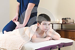 Little boy patient at reception at a professional masseuse. Foot Massage Therapy