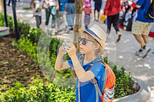 Little boy photographer tourist taking picture with toy camera