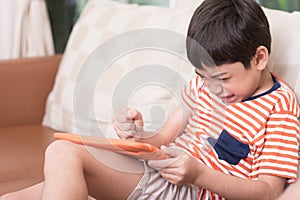 Little boy play game tablet with angry feeling