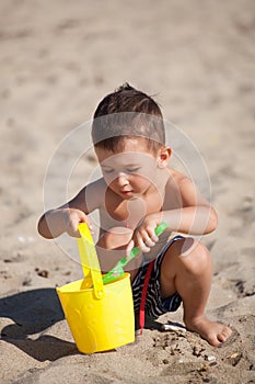 Little boy play with sand on summer beach