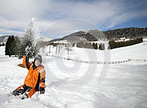 Little boy play with snow in the mountains