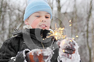 Little boy play with sparkler in forest