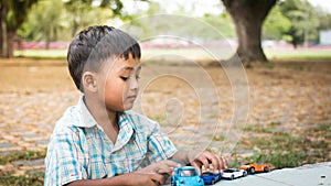 little boy play toy car in the green park