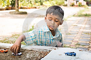 little boy play toy car in the green park