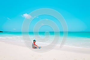 Little boy play with toys and sand on beach