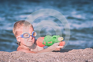 Little boy play with water gun. Instagram stylization