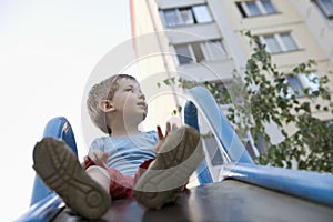 Little Boy On The Playground Slide