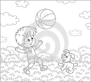 Little boy playing a ball with a merry puppy