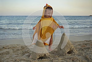 Little boy playing on beach and making sand castles