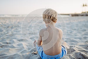 Poco ragazzo sul Spiaggia posteriore 