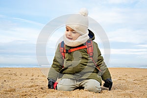 Little boy playing on beach in winter