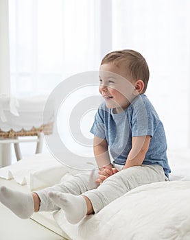 Little boy playing in a bed