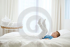 Little boy playing in a bed