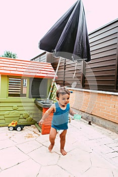 Little boy playing with bucket and water at home confinement covid19