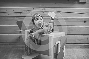 Little boy playing with cardboard airplane