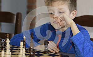 Little boy is playing chess.