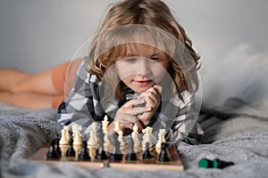 Little boy are playing chess at home. Kid thinking about chess. The concept of learning and growing children. Chess