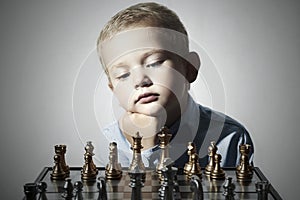Little boy playing chess.Smart kid.Little genius Child. Intelligent game.Chessboard