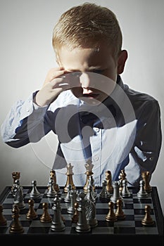Little boy playing chess.Smart Little genius Child. Intelligent game.Chessboard