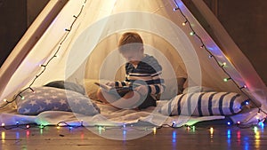 Little boy playing in children's tent at home. Happy caucasian kid in the playroom.