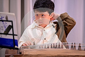 little boy playing the Chinese zither