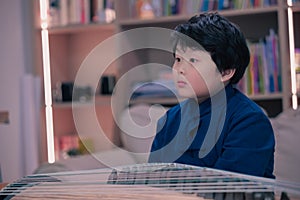 little boy playing the Chinese zither