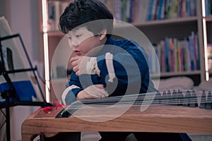 little boy playing the Chinese zither