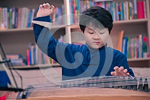 little boy playing the Chinese zither