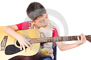 Little boy playing classic guitar course on white background