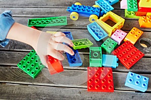 Little boy playing with colorful plastic construction blocks