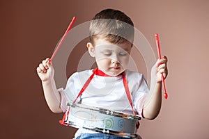Little boy playing the drum. Child development concept.