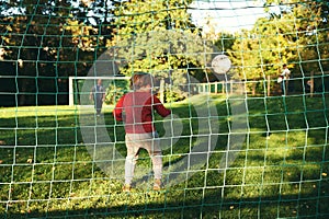 Little boy playing football with his father