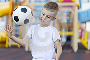 Little boy playing football soccer on the field