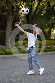 Little boy playing football soccer on the field