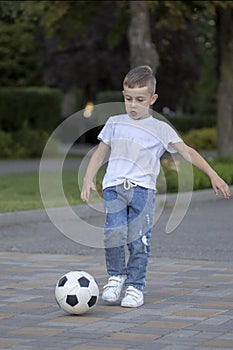 Little boy playing football soccer on the field