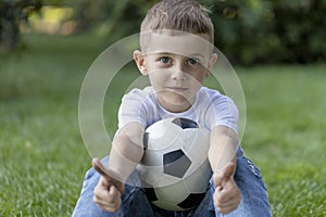 Little boy playing football soccer on the field