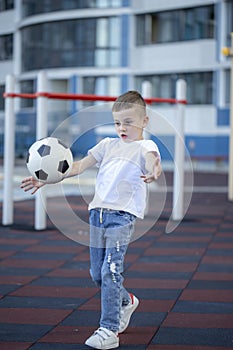 Little boy playing football soccer on the field