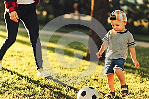 Little boy playing football on the soccer field on a sunny day. Healthy leisure of preschool children
