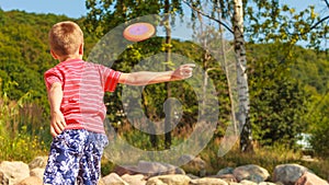 Little boy playing with frisbee disc. photo