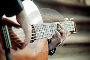 Little boy playing guitar close-up