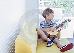 A little boy is playing guitar in living room