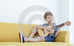 A little boy is playing guitar in living room