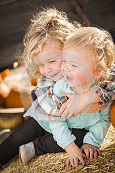 Little Boy Playing with His Baby Sister at Pumpkin Patch