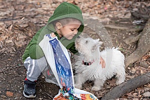 Little boy playing with his pet. Boy play with puppy. Children and dog in garden.