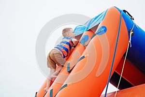 Little boy playing on an inflatable playground on the beach