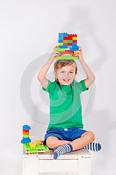 Little boy playing with lots of colorful plastic blocks constructor .